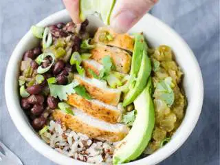 辣墨西哥风味蛋白质碗,撒上新鲜新鲜芫荽 和一点楔形酸橙。