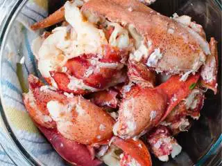 越南风味龙虾卷,将爪子拔掉，扭开头尾，使之分离，用锋利的厨房剪刀剪开壳直到你可以拿出整个尾巴里的肉，用钳子夹开爪子，拿出肉.