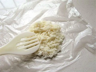 熊猫杯子减肥便当,保鲜膜先擦一滴油防粘,然后将温热米饭平铺在保鲜膜上
