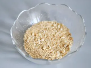 武汉小吃 糯米包油条,用料理机将放凉的花生米、白芝麻打成粗粉状,并加入白砂糖搅拌均匀,备用。