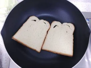 （创意菜）老干妈风味咸鸭蛋酒肠三明治,平底锅上灶开火预热，锅热后调小火煎吐司（不用放油）
