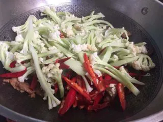 家常干锅花菜,倒入菜花和辣椒加少许盐大火翻炒至出水 