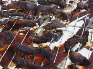 八珍盛宴：过年少不了的零食风味牛肉干 ,放入烤箱,4个小时，牛肉表面变干但是还很有嚼劲