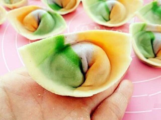 彩虹馄饨(宝宝超爱吃),把下面两个角往里带捏在一起,馄饨就包好了。