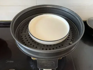 经典小吃驴打滚,放入锅中，盖上保鲜膜，戳洞上锅蒸二十分钟