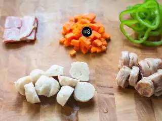 没有烤箱照样做出香浓芝士风味薄底披萨,所有的蔬菜和肉类都切块或切丁,考虑到平底锅温度低于烤箱的缘故,食材尽量切得小一些,更容易熟。 披萨上放置的蔬菜尽量选择水分较少的品种,以免烹煮时析出的水分过多,与芝士融合后变成一滩湿腻腻的糊糊。如果蔬菜本身水分过多,也可以事先在锅内翻炒一下,蒸发去多余的水分。大个头的肉丸,也可以事先汆水成半熟状态备用。