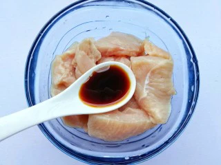 蜜汁香煎鸡胸肉,鸡胸肉中放入一勺生抽。