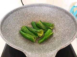 超级下饭菜 油焖尖椒,油温5分热的时候加入小辣椒，全程小火煎制