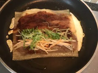 街头风味东北烤冷面,铺上一半的生菜丝