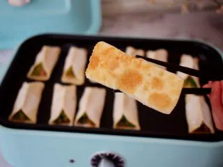 猪肉韭菜锅贴,小火煎至底部变成焦黄色，锅贴皮呈半透明状