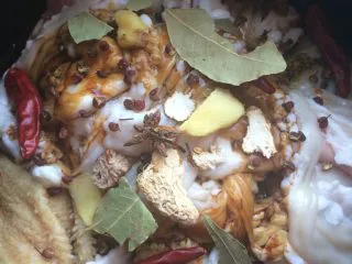 自制老北京小吃【卤煮】,如图将清洗干净的羊肚羊肠子,放入压力锅,倒入一整瓶香糟卤,加入香叶,八角,花椒,黑胡椒颗粒,生姜片,干辣椒,丁香,山奈,肉豆蔻,草果,白酒,盐巴,上气压十五分钟,不开盖保温四个小时