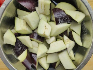 西红柿烧茄子,将茄子先切条再滚刀切成块，放入盆中加入盐腌制，使茄子中多余的水稀释出来，这样不至于水唧唧的口感。