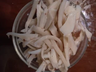 自制年夜饭饮料-------椰肉牛奶热饮,蒸好椰子壳用菜刀削掉表面的叶子皮，然后用锤子慢慢的起开椰子壳，用勺子挖出椰肉，用刀切成细丝备用。