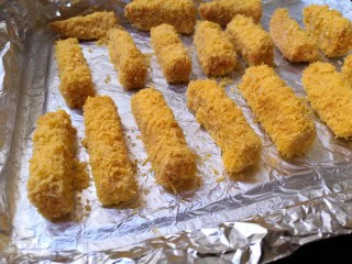 十味 香酥南瓜条,把裹好面包糠的南瓜条，放在刷有油的锡纸上。