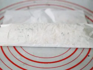 武汉小吃 糯米包油条,用卷寿司的手法,用油纸卷起糯米包上油条。