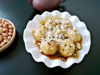  人气小吃糖不甩,将混合好的果仁倒在圆子上，搅拌均匀