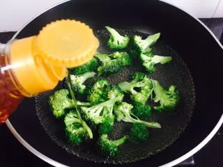 西兰花炒白玉菇,加入适量的花生油