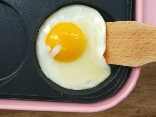 复刻街头美食~网厨第一个肉蛋堡,看底部凝固了,就可以用工具把鸡蛋慢慢铲起,用夹子也可以。