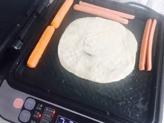 手抓饼——完美复制街头小吃,电饼铛或者平底锅,放少许油,放入饼坯 空余的地方可以放入火腿肠和鸡蛋