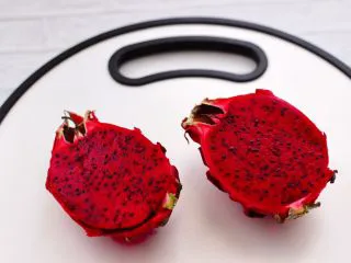 火龙果小番茄蜂蜜果汁,火龙果清除外面杂质后，洗净用刀切两半。