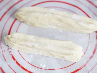 武汉小吃 糯米包油条,切好的面皮两两叠在一起,拿一根筷子,在中间压紧,两端用手捏紧。