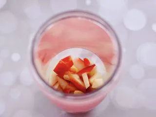 水蜜桃车厘子奶昔,把切小块的水蜜桃，放入料理杯。