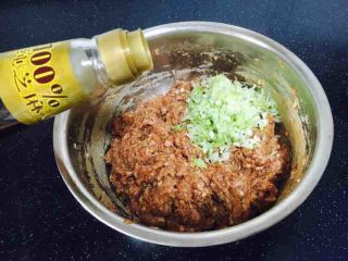 家乡风味饺子 三鲜馅饺子,最后放入葱花，在葱花上放约20g左右的香油，先用香油把葱花拌匀，再将葱花与肉馅充分调匀，即朝一个方向搅拌均匀，大约搅拌100下左右。 先用油裹住葱花的目的是防止葱汁外溢，造成肉馅葱味过重。猪肉馅调好了备用。 
