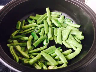 低油低盐健康美味下饭菜 牛背筋粉丝煲,先放入豆角，煸炒几下，放入少许水，盖上锅盖儿焖5、6分钟。 水是食材量的四分之一即可。