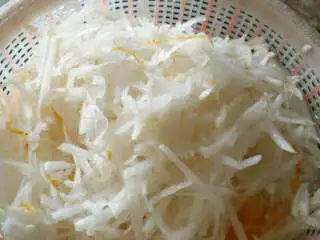 松阳特色小吃灯盏盘,把萝卜擦丝用刀切碎。