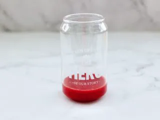 蔓越莓草莓花茶饮,取一个自己喜欢的杯子,把榨好的蔓越莓泥倒入杯底。