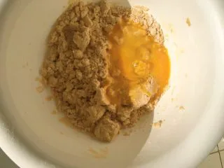 从小吃到大都吃不腻的黑芝麻桃酥,倒入搅拌均匀的鸡蛋液,继续用一次性手套混合在一起。