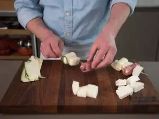 地中海风味菲达芝士烤串,将西葫芦菲达卷、熏火腿菲达卷和哈密瓜块依次插到木叉上。
