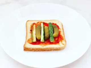 风味酸黄瓜鸡肉热压三明治,上面分别码上黄瓜条和酸黄瓜。