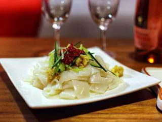 陕西小吃—凉皮,将黄瓜丝、芝麻酱、花生、辣椒蒜蓉酱倒入凉皮中搅匀即可食用!