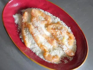 街头小吃自己做---香酥无骨鸡柳,另取一个盘子倒入面包糠,再将裹好蛋液的鸡肉包裹一层面包糠。