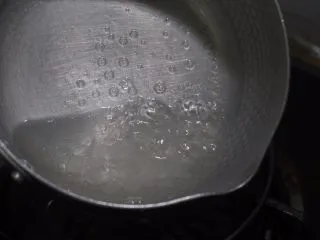 老北京小吃之冰糖葫芦,中小火摇滚着锅,让冰糖快速融化在水里。