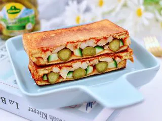 风味酸黄瓜鸡肉热压三明治,做好的三明治，用刀一切两半就可以享用了。 