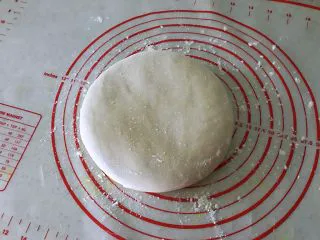 姜黄花卷，饮料做,面团拿出来在案板上揉几下后，用擀面擀成3毫米薄椭圆形。