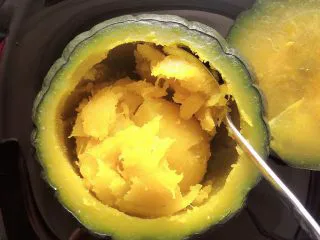 贝贝南瓜坚果饮,将蒸软的南瓜瓜肉掏出来待用。