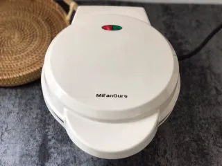 香港名小吃鸡蛋仔,待绿灯灭了,红灯一个亮着时,打开盖子,观察鸡蛋仔熟的程度来判断鸡蛋仔有没有熟,没熟就继续再烤一会儿