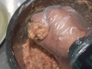 老北京小吃之“干炸小丸子”,做丸子造型很简单,攥一把肉馅在手里,先用大拇指把肉馅抹一把变圆滑,再从虎口处往外挤就是个丸子造型。