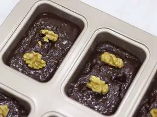 秋冬能量甜点—布朗尼, 将布朗尼面糊装入裱花袋后挤入模具约9分满。表面可以用比较完整的核桃仁进行装饰