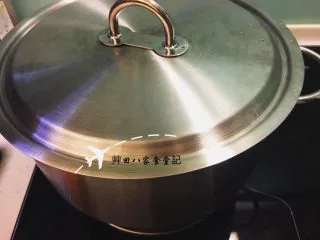 無油拔絲地瓜-台灣夜市小吃,蓋上鍋蓋,轉小火燜煮約15分鐘,利用鍋內熱循環的原理讓砂糖融化因爲所有的水汽都聚集於鍋內,可以使地瓜快速熟透,保持鬆軟與甜度(開始燜煮的後5分鐘時可以打開鍋蓋將融化的糖與地瓜拌勻,接著蓋上鍋蓋)