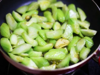 鲜掉眉毛的丝瓜豆腐汤,把丝瓜放入锅中翻炒至变色,往锅中倒入清水没过丝瓜烧开。