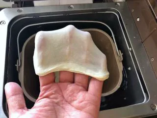 河南小吃-羊肉烩面,8、将水倒入面粉中启动面包机的揉面功能20分钟,面团达到非常好的延展性。