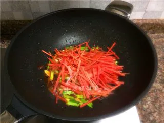 胡萝卜炒牛肉丝,放入胡萝卜丝翻炒20秒。