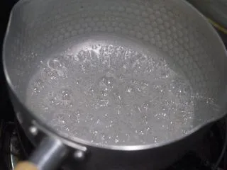 老北京小吃之冰糖葫芦,看这个状态有很多大的糖泡说明水份已经蒸发了逐渐像糖浆转化,如果这个时候冰糖还没有完全化开要继续加点水帮助冰糖溶解。如果用的是白糖在白糖没有充分溶解但水份已经蒸发没的时候就放山楂那做出来的就是滚雪球…,