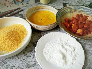 #猪年#新奥尔良小酥肉,第二天把肉取出，一个碗里磕鸡蛋，一个碗里放淀粉，一个碗里放入黄色面包糠，如图