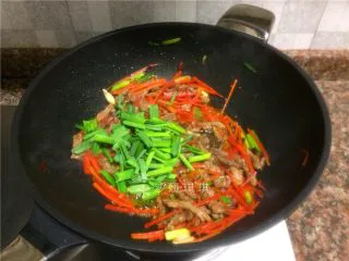 胡萝卜炒牛肉丝,放入蒜苗叶翻炒10秒。