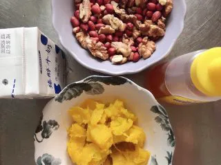 贝贝南瓜坚果饮,准备好其他食材。烤熟的红皮花生和核桃仁，牛奶、蜂蜜、蒸好的南瓜。